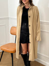 Trench beige femme avec ceinture, manches longues et col volanté pour une touche féminine. Boutons tout le long, doublure intérieure en carreaux vichy marron et écru, offrant élégance et confort. Coupe ample et deux poches latérales pratiques.