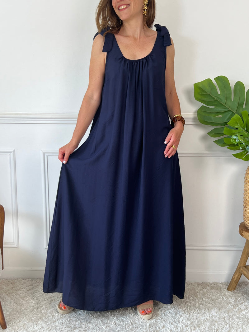 Sa coupe ample assure un confort optimal tout au long de la journée. Sans manches, elle présente des liens à nouer aux épaules pour une touche élégante et ajustable. Son col rond, à l’avant comme à l’arrière, est agrémenté d’un élastique qui garantit un maintien parfait sans contrainte.