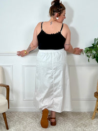 La jupe blanche plissée de grande taille incarne une élégance intemporelle. Avec sa coupe longue, elle offre une silhouette flatteuse et tendance. Cette pièce allie style et confort, créant une tenue sophistiquée et moderne pour les femmes de grande taille.