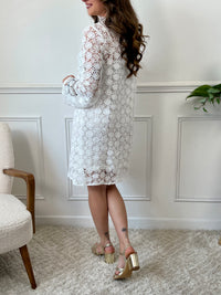 Une pièce féminine et élégante. Avec ses manches longues évasées et son col V orné de volants, cette robe en broderie ajourée est un véritable plaisir pour les yeux. Les boutons dorés et écrus ajoutent une touche de glamour, tandis que la doublure en bretelles assure un confort optimal.