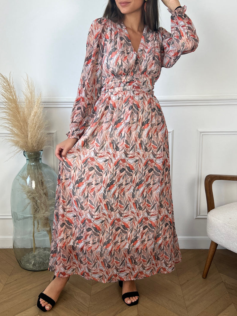 Une robe longue avec une taille élastique au dos, qui épouse délicatement la silhouette pour un confort optimal. Elle se distingue par ses motifs aux tons rose, gris, et terracotta, qui créent un mélange harmonieux de couleurs. Cette robe fluide et féminine est parfaite pour un look à la fois élégant et décontracté, idéale pour les occasions où style et confort vont de pair.