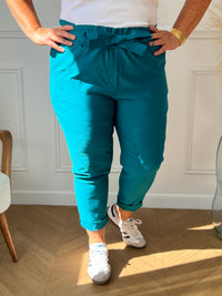 Ce pantalon bleu canard grande taille, modèle Kelly, allie confort et style grâce à sa taille élastique qui s’adapte parfaitement à votre silhouette. Sa matière extensible offre une grande liberté de mouvement, tandis que la ceinture amovible ajoute une touche personnalisable à votre tenue