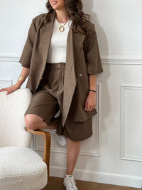 Ce bermuda taupe Delfine allie confort et praticité avec sa taille élastique au dos et ses passants pour ceinture. Il dispose de deux poches latérales et d’une poche arrière, offrant un espace de rangement fonctionnel. Sa fermeture éclair et son bouton à l’avant assurent un maintien sûr tout au long de la journée.