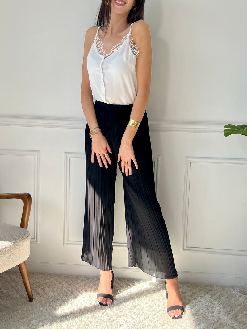 Léger et élégant, ce pantalon plissé noir séduit par sa coupe fluide et sa teinte chaude. Parfait pour une silhouette allongée et un style tout en douceur.
