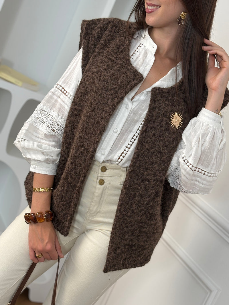 Adoptez l’élégance cosy avec cette veste sans manches marron effet moumoute. Confortable et tendance, elle se porte facilement sur vos tenues pour un look chic et décontracté. Son détail raffiné : une broche dorée amovible, qui apporte une touche lumineuse et personnalisable à votre style.
