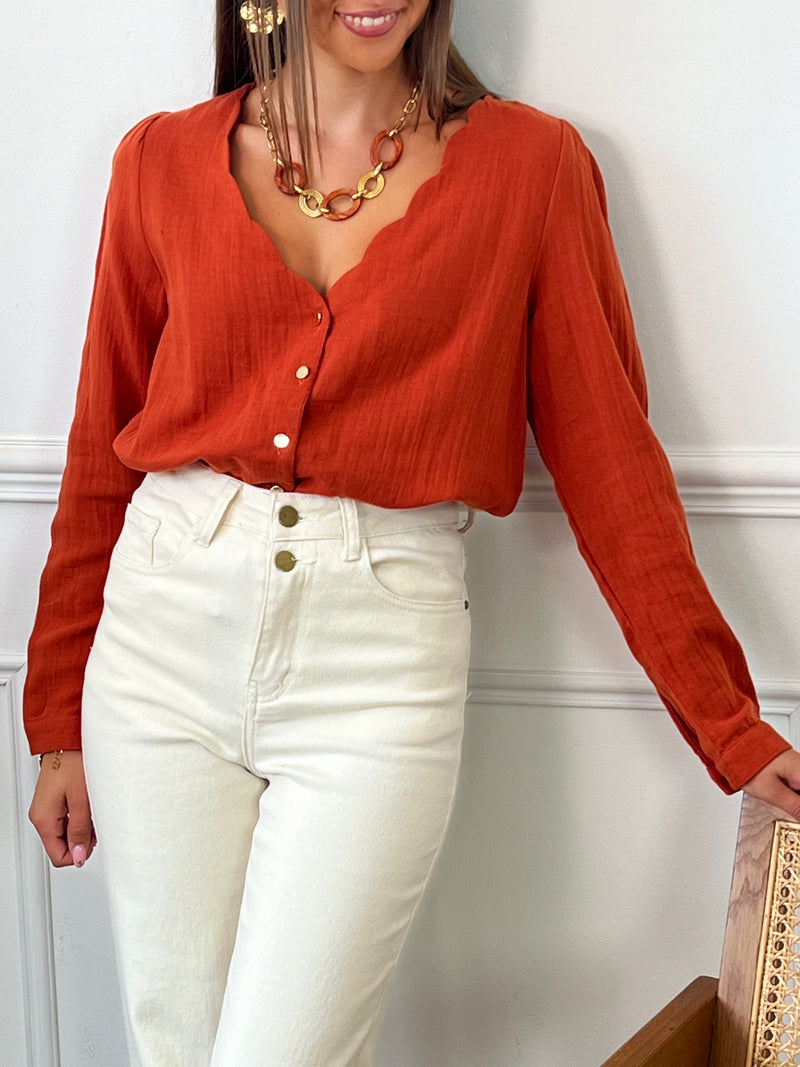 Une chemise à manches longues en gaze de coton terracotta, parfaite pour allier confort et style. Son col V festonné ajoute une touche délicate et féminine, tandis que la texture légère et douce du tissu assure une sensation agréable sur la peau. Idéale pour créer une tenue élégante tout en restant décontractée, cette chemise se distingue par son charme naturel et son allure intemporelle.