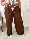 Ce pantalon marron grande taille Karoline est un essentiel pour toutes les femmes. Très confortable avec son élastique au dos et ses poches latérales à l'avant, il ajoute une touche de style avec sa ceinture amovible à motifs assortie au haut Alena.