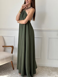 Adoptez une allure audacieuse avec cette robe longue kaki Adeje. Son col montant réglable, orné d’un détail doré, apporte une touche sophistiquée tandis que l’élastique au dos assure un confort parfait. Sans manches et à la coupe ample, elle offre une liberté de mouvement idéale pour affirmer votre style avec assurance.&nbsp;