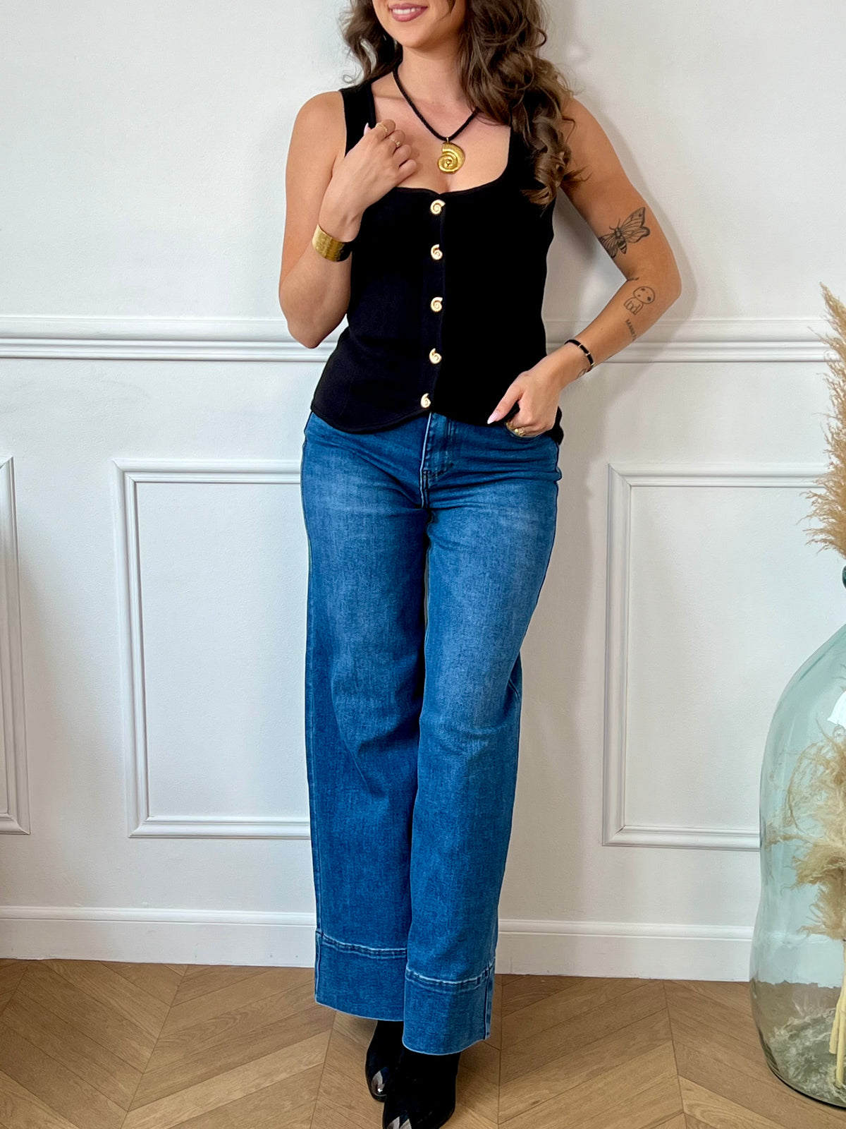 Gilet sans manches au charme vintage, doté d’un col carré structuré et rehaussé de boutons dorés en forme de coquillage. Une pièce délicate et originale, parfaite pour apporter une touche de caractère à vos tenues.