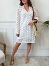 Une pièce féminine et élégante. Avec ses manches longues évasées et son col V orné de volants, cette robe en broderie ajourée est un véritable plaisir pour les yeux. Les boutons dorés et écrus ajoutent une touche de glamour, tandis que la doublure en bretelles assure un confort optimal.