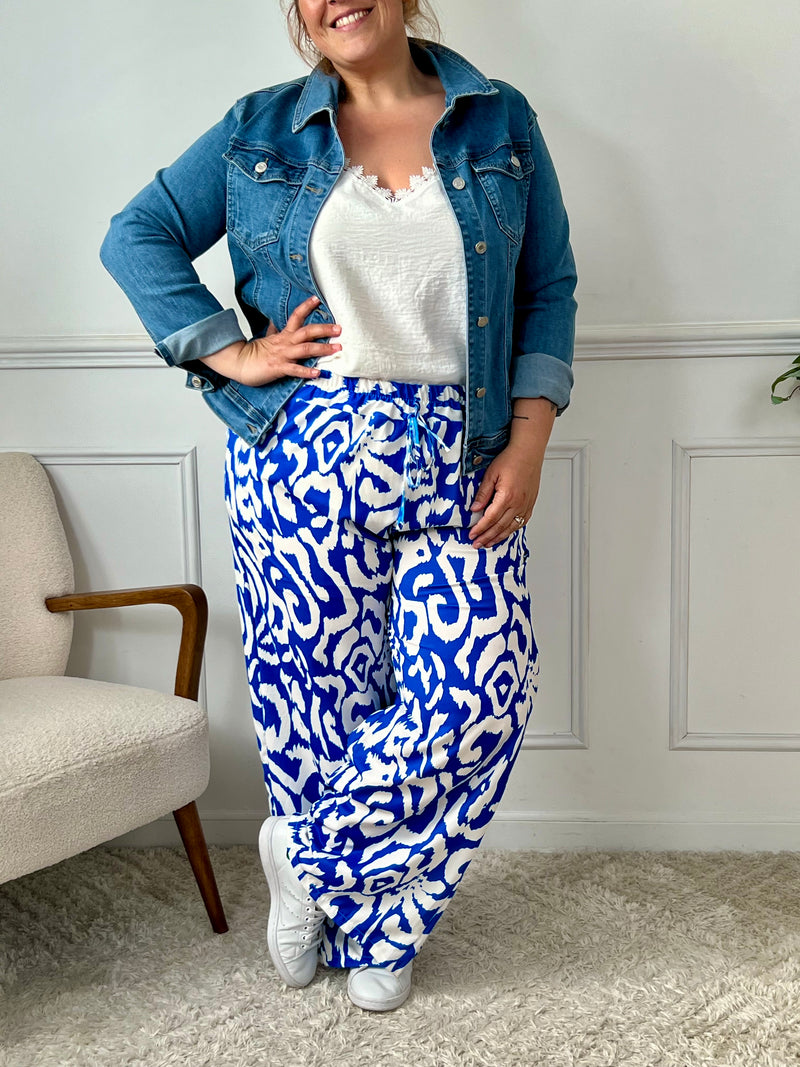 Sublimez votre silhouette avec le pantalon Linzy, une pièce audacieuse en bleu ornée de motifs élégants. Sa coupe ample célèbre vos courbes tout en garantissant un confort optimal pour toutes les occasions.