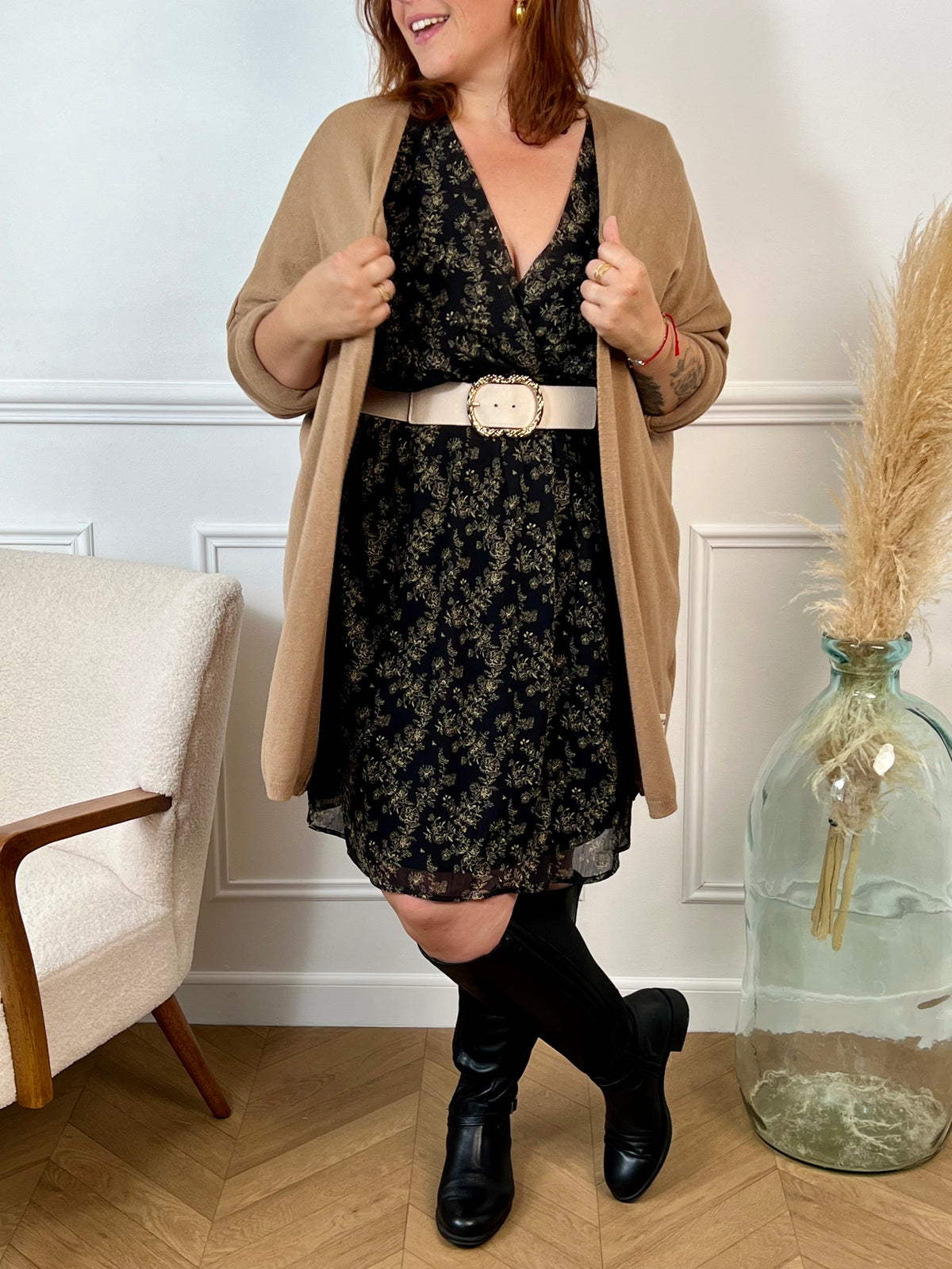 La robe courte Timy offre confort et élégance avec ses manches longues, son col cache-cœur et sa ceinture amovible. Ses motifs floraux en noir et beige donnent une touche élégante et féminine à cette pièce facile à porter au quotidien ou pour des occasions spéciales.