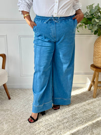 Révélez votre élégance avec le pantalon bleu Eline grande taille ! Sa coupe droite et taille haute flatte votre silhouette. Pratique avec ses poches avant et arrière, il s'ajuste parfaitement avec son élastique et ses liens de serrage.