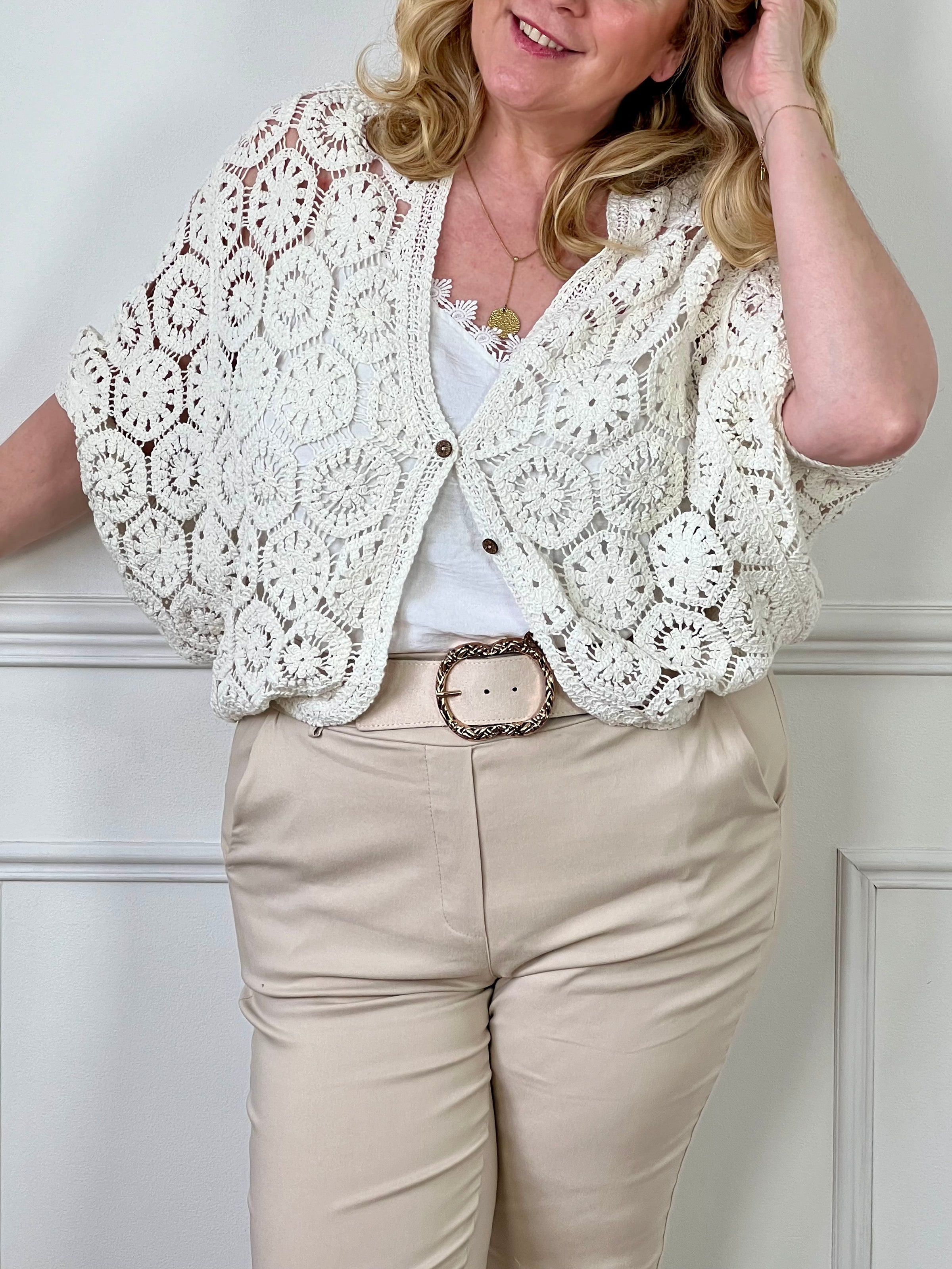 Optez pour le confort et le style avec notre gilet crochets écru Ela. Confectionné avec du tissu de qualité, ce gilet est orné d'une broderie élégante et de boutons marrons le long de la fermeture. Avec son design intemporel, il ajoutera une touche de sophistication à toutes vos tenues.
