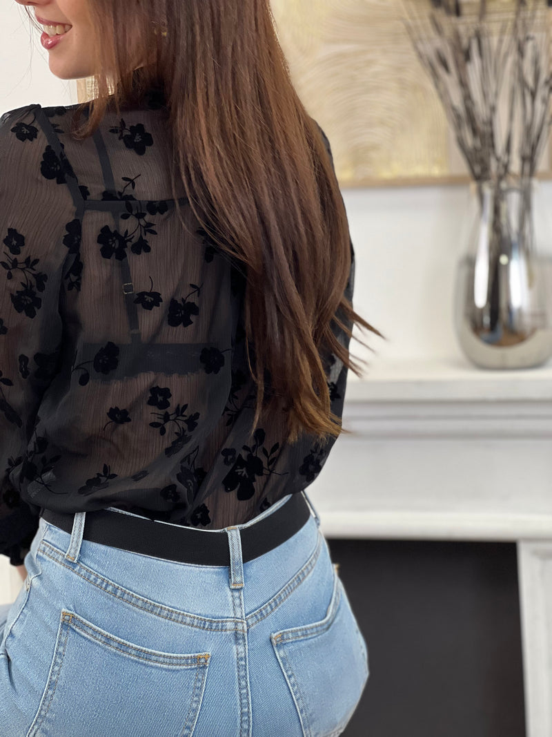 Cette chemise noire à motifs floraux Elenora allie élégance et délicatesse. Ses manches longues et son col rond apportent un charme classique, rehaussé par des volants subtils au col et aux manches.