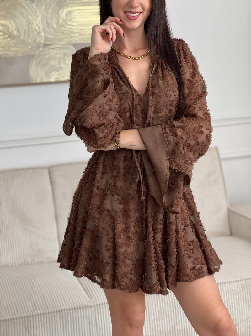 Délicate et féminine, cette robe marron clair séduit par ses volants élégants et son motif en relief au toucher doux. Une pièce pleine de charme, à la fois confortable et raffinée, parfaite pour toutes les occasions.