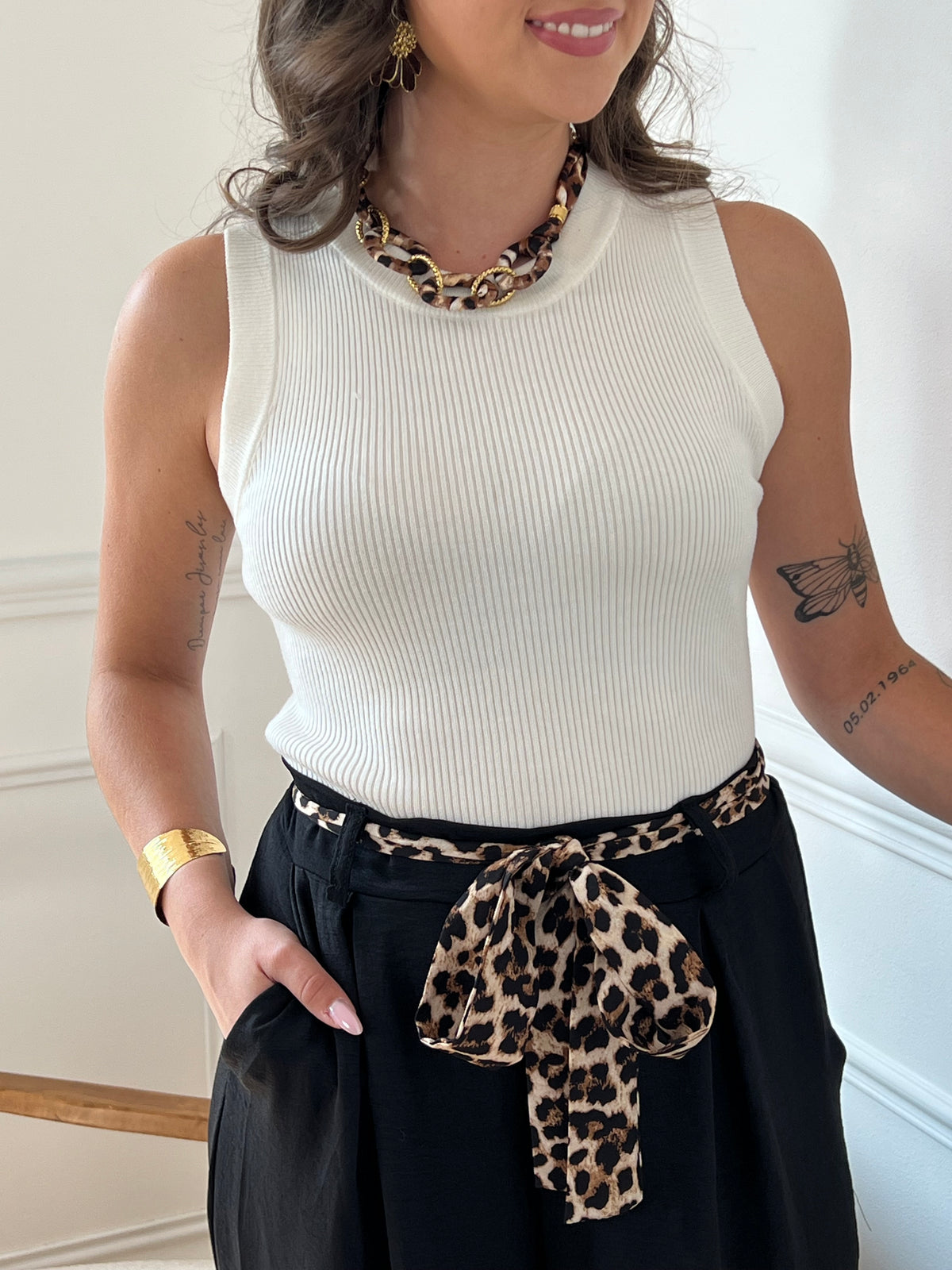 Ce pantalon noir Karoline est un essentiel pour toutes les femmes. Très confortable avec son élastique au dos et ses poches latérales à l'avant, il ajoute une touche de style avec sa ceinture amovible à motifs léopard.