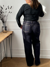 Jean bleu foncé intemporel au style affirmé. Coupe large et confortable avec taille haute qui épouse vos formes avec élégance.