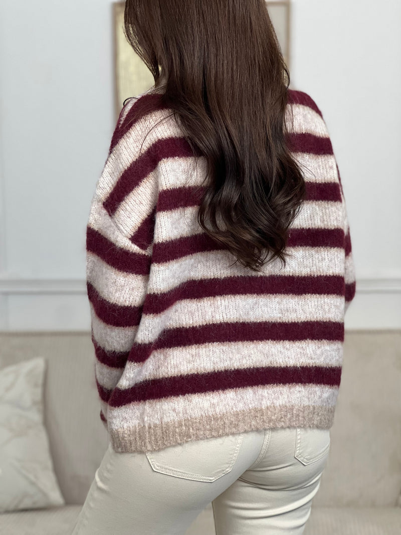 Chic et confortable, ce pull rayé bordeaux et beige séduit par son col montant modulable, rehaussé d'élégants boutons dorés. Une pièce douce et stylée, parfaite pour un look à la fois cosy et raffiné.