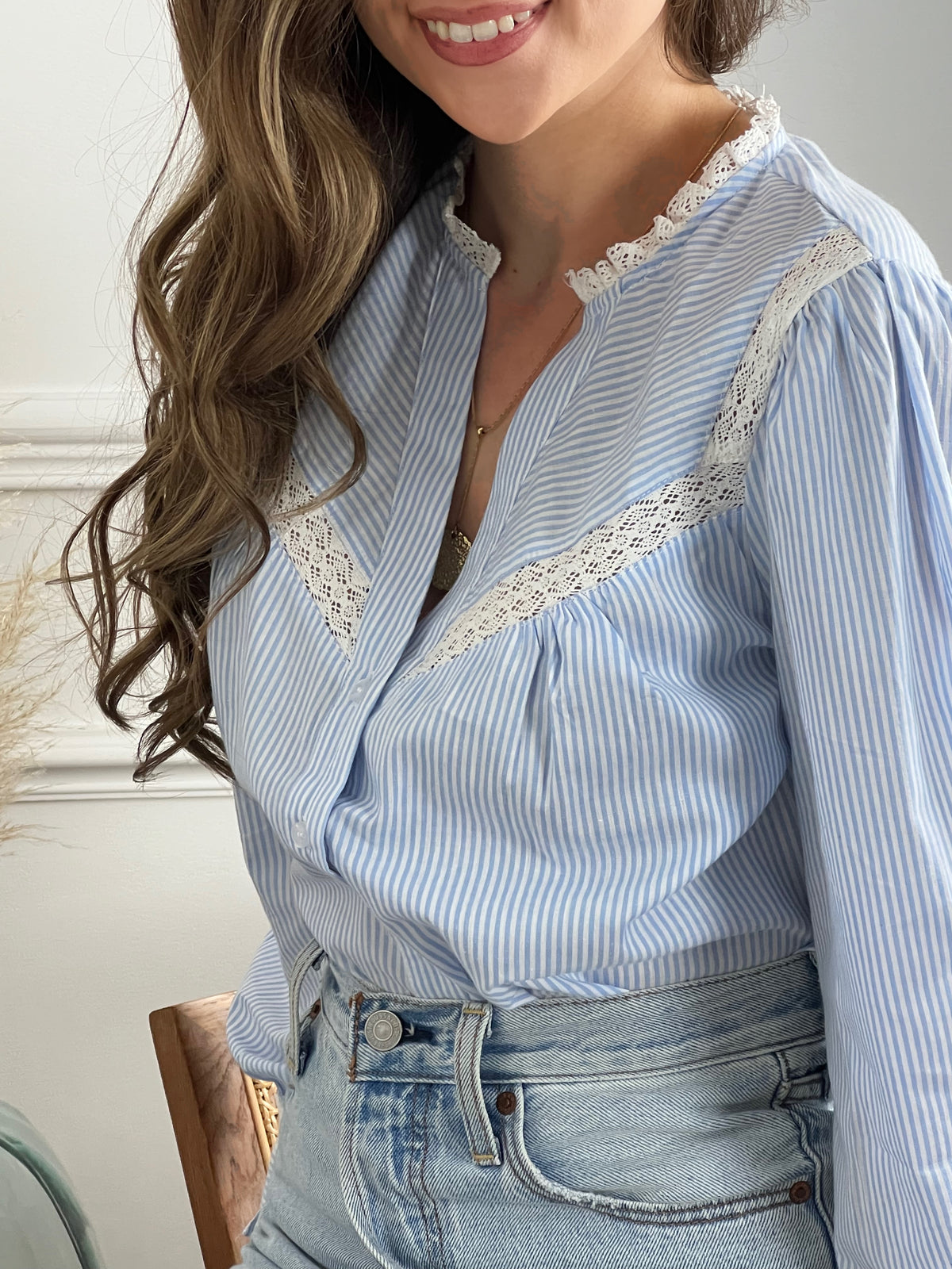 Cette chemise à rayures bleues et blanches est sublimée par des broderies raffinées, ajoutant une touche d'originalité. Parfaite pour une élégance décontractée, elle allie avec brio le charme traditionnel au chic contemporain, faisant d'elle un incontournable de toute garde-robe moderne