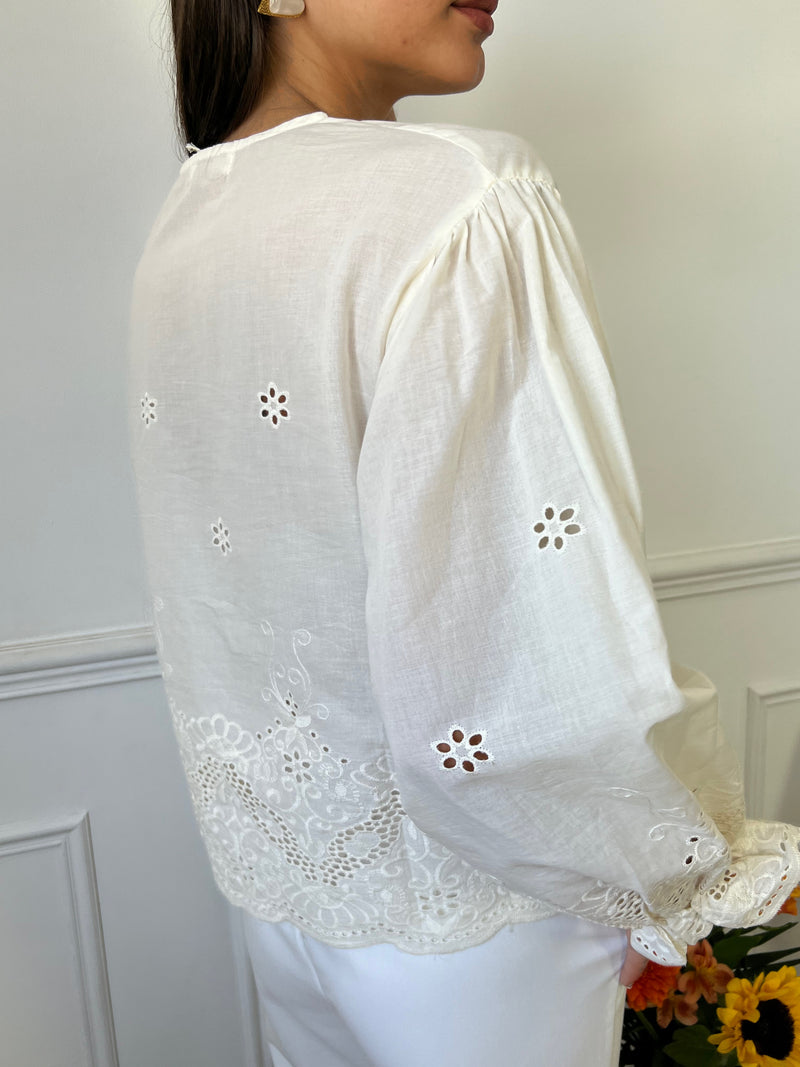 Découvrez la blouse écrue Daliana avec ses broderies délicates et son col V, pour une touche de féminité. Légère et ajourée, elle est idéale pour les journées ensoleillées. Les manches élastiques et le lien de serrage sur le devant ajoutent une note pratique et confortable.