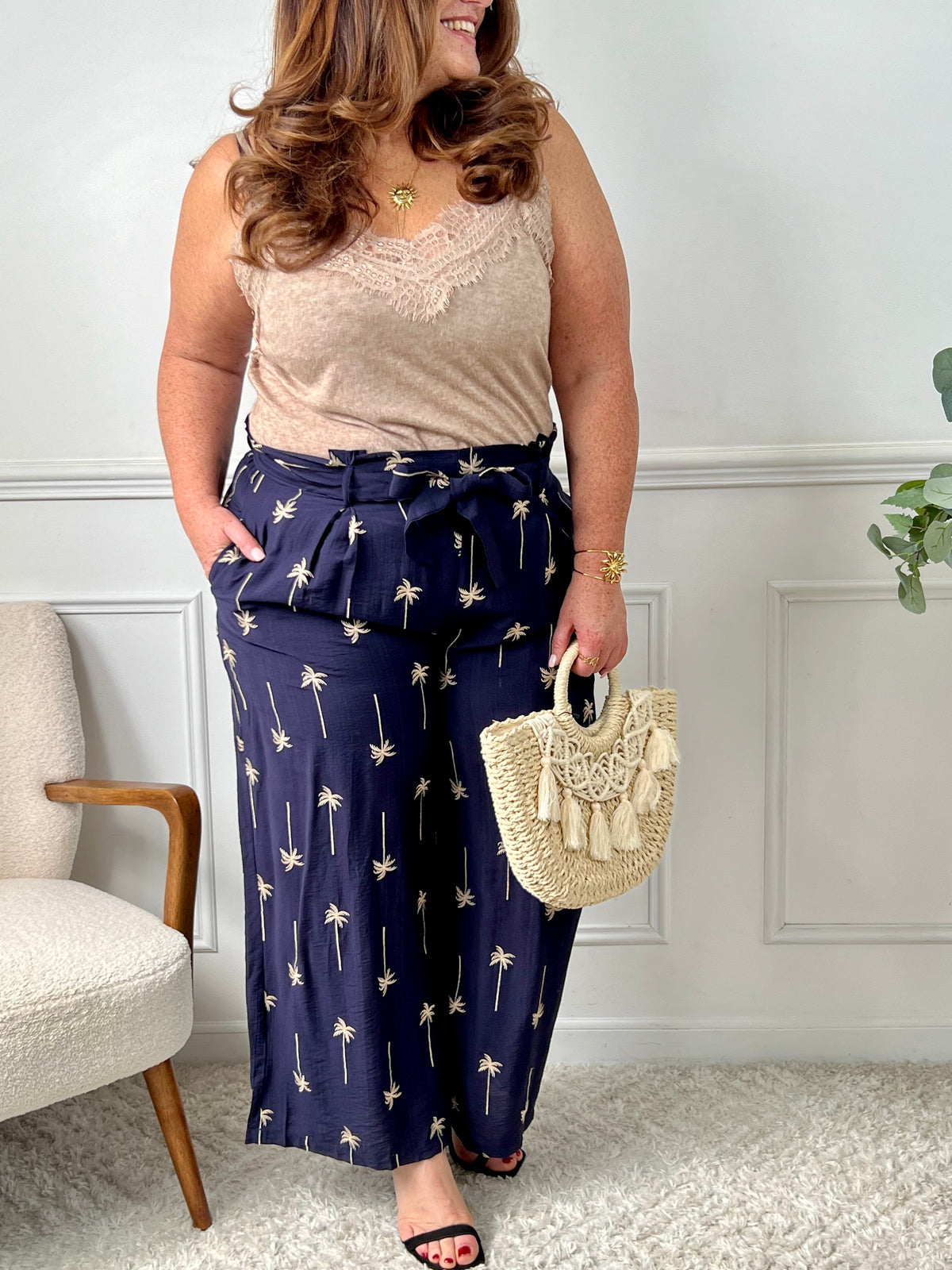 On craque pour ce pantalon bleu marine fluide et raffiné, habillé de délicats motifs palmier beige. Idéal pour un look à la fois chic et dépaysant, parfait en toute saison.