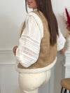Cette veste sans manches camel Maelia combine douceur et style avec sa moumoute chaleureuse et son col rond confortable. Les motifs floraux apportent une touche féminine et délicate, idéale pour rehausser vos tenues tout en restant confortable.