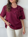 Tee-shirt bordeaux pour femme – Ce tee-shirt à manches courtes est doté d’un col rond et d’un nœud sur le devant pour une touche féminine. Confectionné dans une matière épaisse pour un tombé structuré. Couleur bordeaux, idéale pour la mi-saison.
