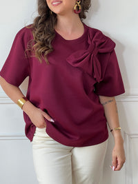 Tee-shirt bordeaux pour femme – Ce tee-shirt à manches courtes est doté d’un col rond et d’un nœud sur le devant pour une touche féminine. Confectionné dans une matière épaisse pour un tombé structuré. Couleur bordeaux, idéale pour la mi-saison.