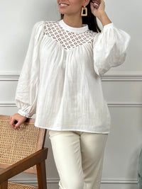 Cette blouse écrue en 100% coton pour femme allie élégance et raffinement avec ses détails ajourés et ses broderies délicates. Conçue avec des manches longues et un col rond, elle présente un bouton discret au dos pour une touche d'originalité. La blouse est doublée à l'avant pour un confort optimal, tandis que les détails ajourés ajoutent une note de sophistication. Sa teinte écrue douce et naturelle s’accorde facilement avec différents styles, idéale pour un look chic et intemporel. Cette blouse en coton 