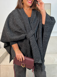 Le Poncho Sorian en gris foncé est la pièce idéale pour un style bohème et fluide. Orné d'une frange latérale élégante et doté d'un passant pour nouer ou fermer, il s'adapte parfaitement à votre silhouette. Confortable et intemporel, ce poncho grande taille accompagne tous vos looks avec grâce.