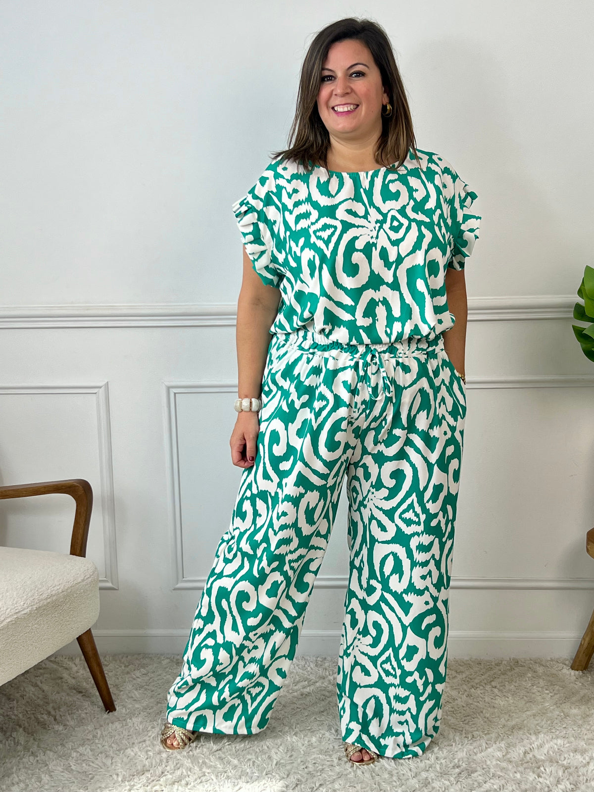 Léger et éclatant, ce top fluide vert et écru sans manches séduit par ses jolis volants aux épaules. Une pièce pleine de fraîcheur et de féminité, parfaite pour égayer vos looks avec une touche raffinée.