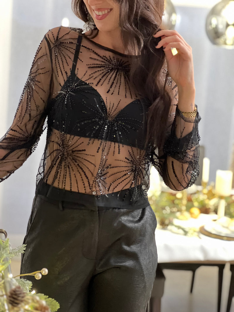 Audacieux et élégant, ce top court noir transparent séduit par ses motifs en sequins scintillants. Une pièce glamour et moderne, parfaite pour sublimer une tenue de soirée avec style.