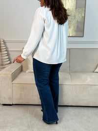 Élégante et délicate, cette chemise écrue fluide se distingue par ses volants au col, apportant une touche de féminité et de charme. Une pièce chic et intemporelle, parfaite pour sublimer n’importe quel look.