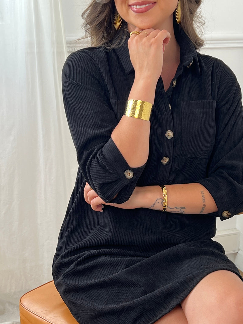 Cette robe courte noire, modèle Cora, allie élégance et confort. Ses manches longues et son col chemise apportent une touche sophistiquée, tandis que les boutons au col et aux manches accentuent son style raffiné.