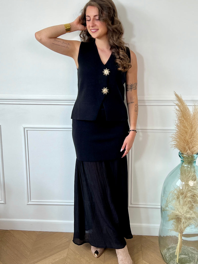 Jupe noire bi matière au style unique : une coupe courte effet pull qui épouse la taille, prolongée par une partie fluide et plissée pour un jeu de textures raffiné. Une pièce audacieuse et féminine, entre confort et élégance.