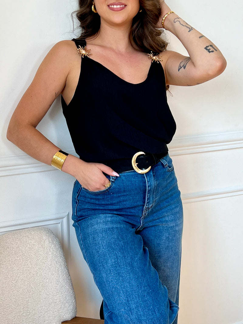 Ce top noir au design épuré séduit par ses bretelles ornées de délicats détails dorés. À la fois sobre et raffiné, il apporte une touche d’élégance à vos looks, de jour comme de nuit.