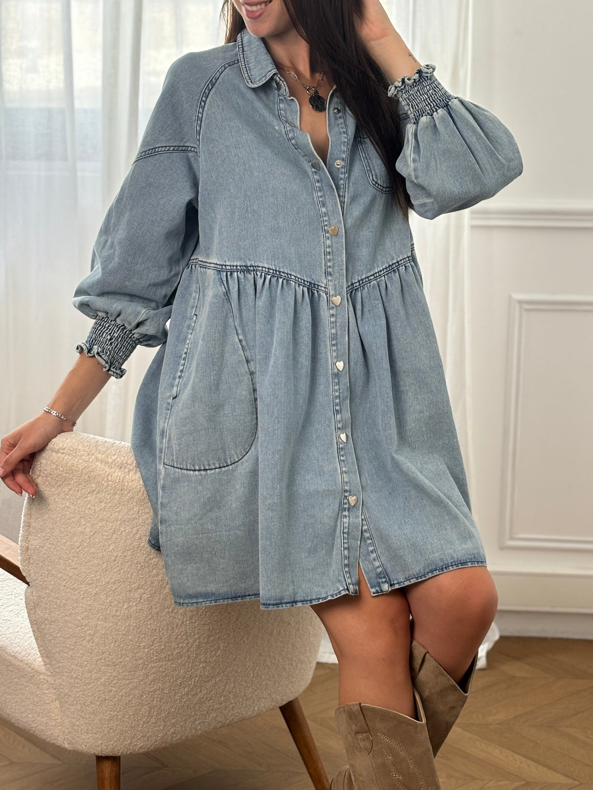Robe en jean bleu clair Anita, courte et confortable. Manches longues avec élastique aux poignets, col chemise, boutons en forme de cœur et deux poches latérales. Coupe ample pour plus de liberté.
