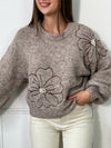 Ce pull beige foncé pour femme se distingue par ses détails délicats et élégants. Conçu avec des manches longues et un col rond classique, il offre un confort idéal tout en apportant une touche de féminité. Les fleurs brodées, ornées de petites perles, ajoutent une note subtile de raffinement, rendant ce pull unique et chic. Parfait pour les saisons fraîches, ce pull s'associe facilement avec des tenues décontractées comme habillées. La couleur beige foncé et les motifs floraux rehaussés de perles font de c