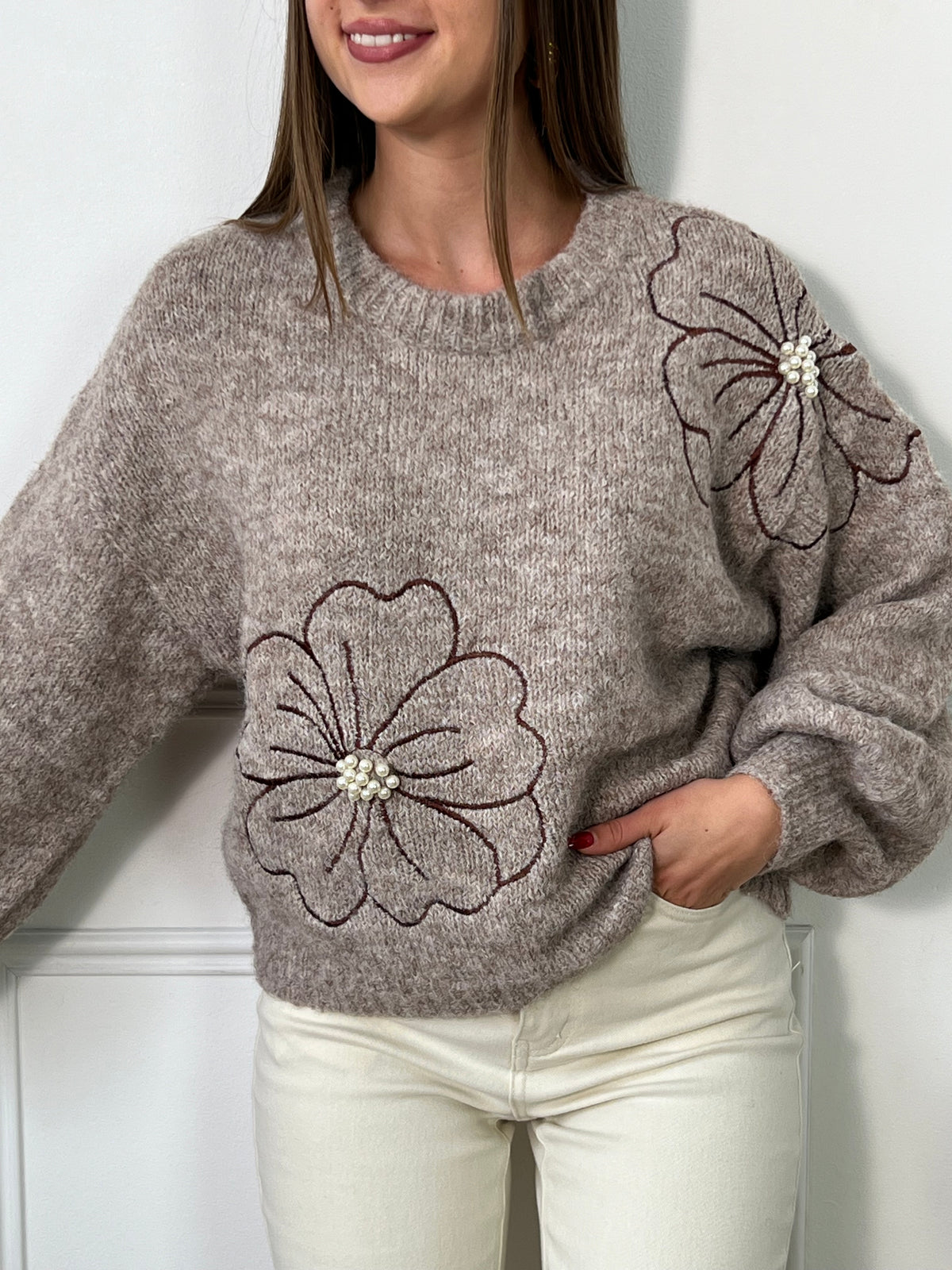 Ce pull beige foncé pour femme se distingue par ses détails délicats et élégants. Conçu avec des manches longues et un col rond classique, il offre un confort idéal tout en apportant une touche de féminité. Les fleurs brodées, ornées de petites perles, ajoutent une note subtile de raffinement, rendant ce pull unique et chic. Parfait pour les saisons fraîches, ce pull s'associe facilement avec des tenues décontractées comme habillées. La couleur beige foncé et les motifs floraux rehaussés de perles font de c