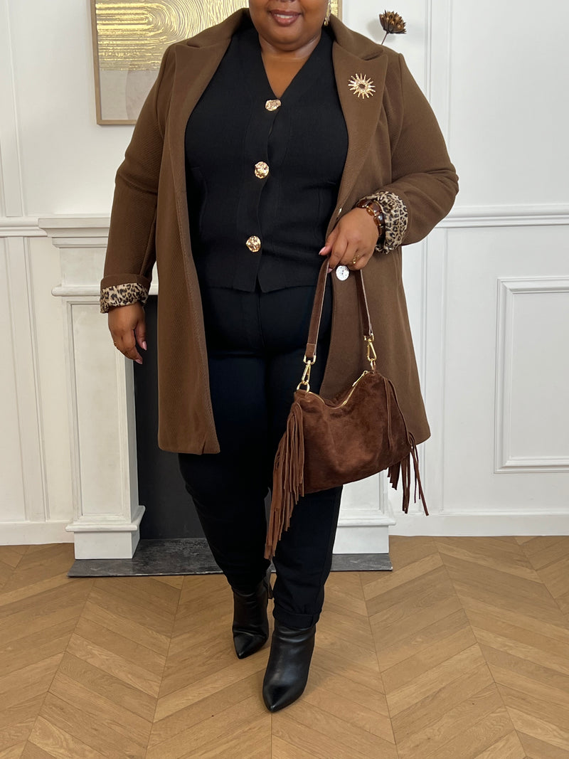 Élégant et raffiné, ce manteau mi-long marron séduit par ses détails sophistiqués. Ses manches à revers dévoilent un intérieur léopard chic et audacieux, offrant une touche de caractère subtile. Les boutons dorés amovibles, délicatement travaillés, viennent parfaire l’ensemble avec une note précieuse et intemporelle.