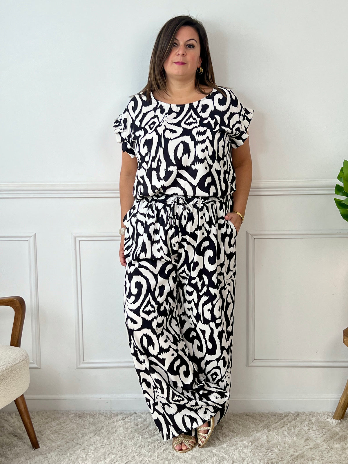 Léger et éclatant, ce top fluide noir et écru sans manches séduit par ses jolis volants aux épaules. Une pièce pleine de fraîcheur et de féminité, parfaite pour égayer vos looks avec une touche raffinée.