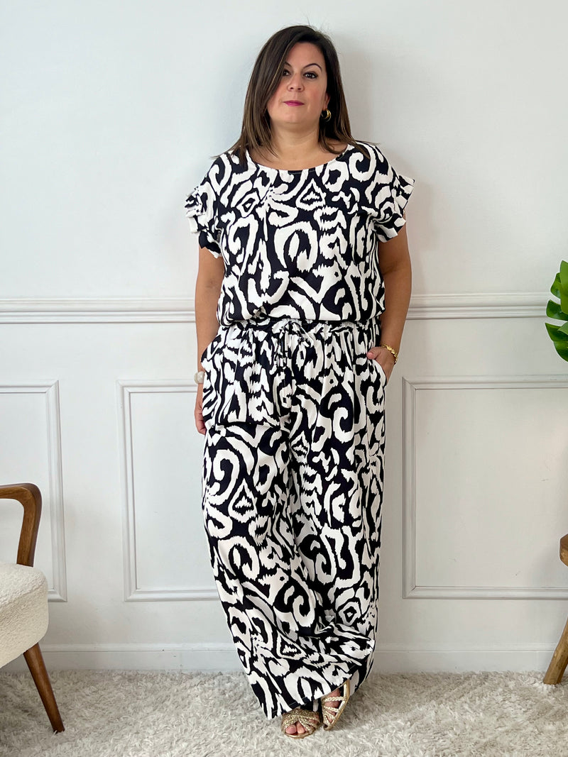 Léger et éclatant, ce top fluide noir et écru sans manches séduit par ses jolis volants aux épaules. Une pièce pleine de fraîcheur et de féminité, parfaite pour égayer vos looks avec une touche raffinée.