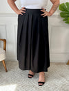 La jupe noire plissée de grande taille incarne une élégance intemporelle. Avec sa coupe longue, elle offre une silhouette flatteuse et tendance. Cette pièce allie style et confort, créant une tenue sophistiquée et moderne pour les femmes de grande taille.