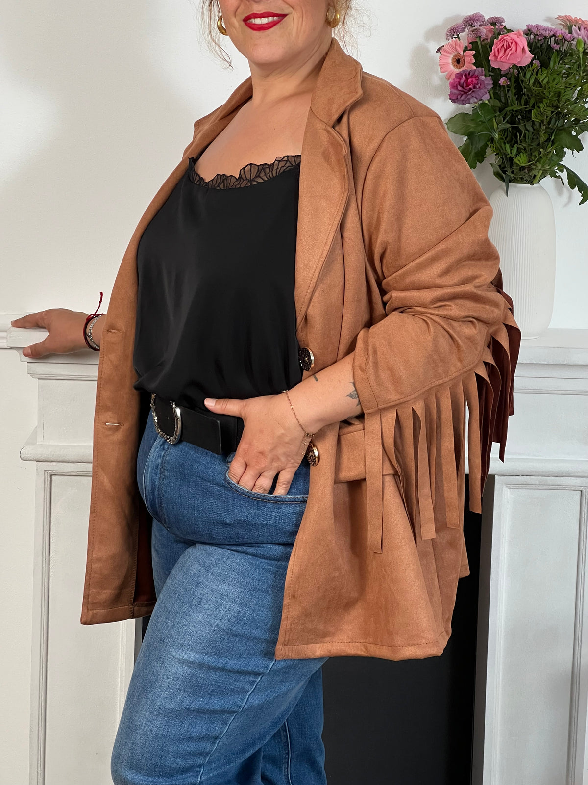 Cette veste camel en effet daim, ornée de franges au dos et aux manches, offre un style unique. Ses manches longues et ses poches latérales pratiques allient élégance et confort, idéale pour les grandes tailles.