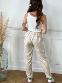 Sentez-vous élégant et confortable avec notre pantalon beige en lin taille haute pour femme, coupe droite. La taille élastique avec lien de serrage vous garantit un ajustement parfait. Les 2 poches à l'avant et les 2 poches à l'arrière avec broderie ajoutent une touche de style pratique.