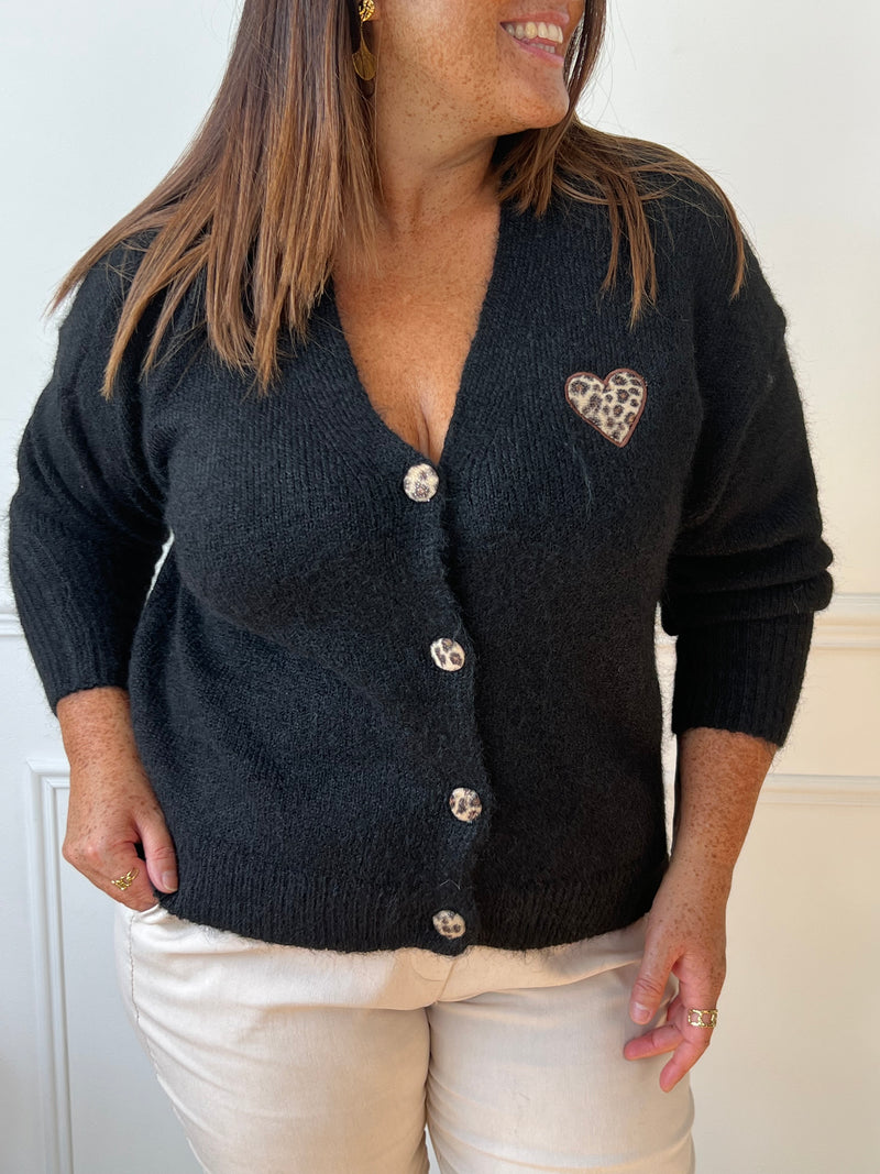 Le gilet noir Curve: Ange allie confort et style avec ses manches longues et ses boutons sur la longueur et aux manches. Avec son coeur brodé motif léopard sur le devant, il ajoutera une touche de fantaisie à toutes vos tenues. Restez au chaud tout en restant tendance avec ce gilet unique !