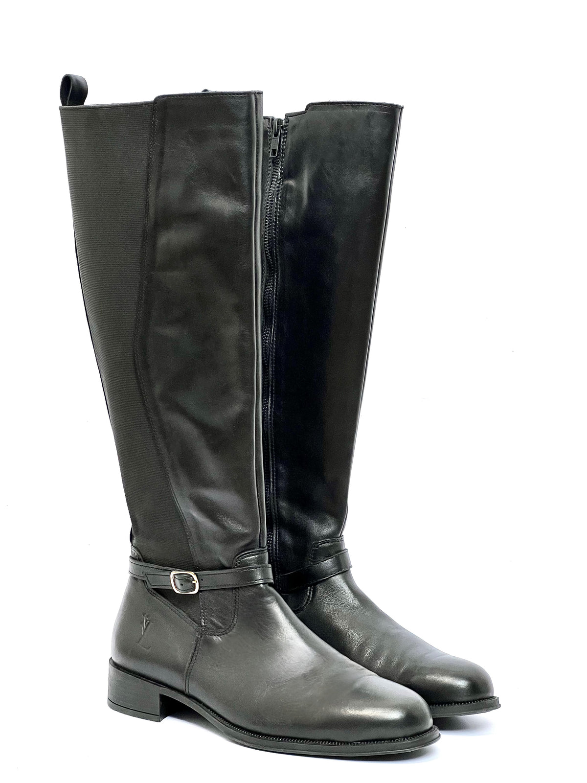 Ces bottes cavalières ont été créées pour accompagner les courbes avec élégance. Pensées spécialement pour les mollets larges, elles allient confort et style grâce à leur élastique d'ajustement et leur sangle raffinée à la cheville. Fabriquées au Portugal avec un cuir 100% de qualité, leur design bi-matière en noir intemporel est parfait pour un look chic et affirmé, tout en célébrant chaque silhouette avec soin.