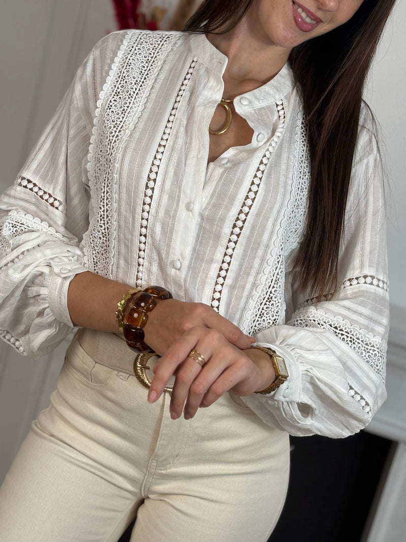 Cette chemise écru séduit par sa délicatesse et son élégance naturelle. Ses détails ajourés, sublimés par une fine broderie, apportent une touche de féminité et de raffinement. Légère et intemporelle, elle se porte aussi bien au quotidien que pour des occasions plus habillées.