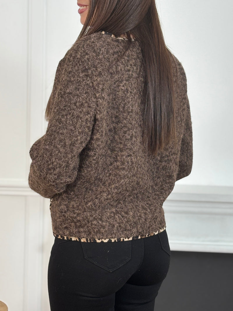 Chic et audacieuse, cette veste marron se démarque par son pourtour souligné d’une fine bande léopard, subtile touche de caractère. Pratique et élégante, elle est dotée de deux poches à l’avant et s’agrémente d’épingles amovibles dorées, offrant la possibilité de personnaliser votre look au gré de vos envies.